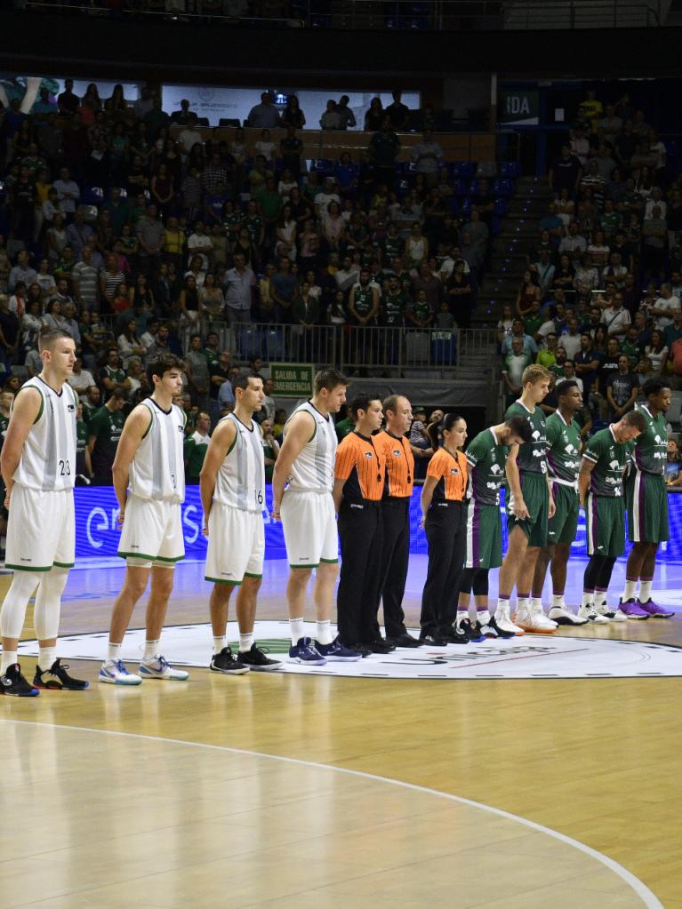 Los quintetos iniciales de los dos equipo y los árbitros durante el minuto de silencio por Javier García