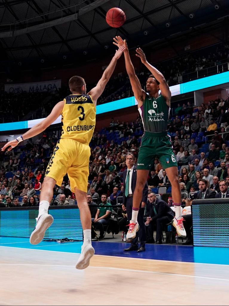 Toupane lanza desde la línea de tres puntos presionado por un rival