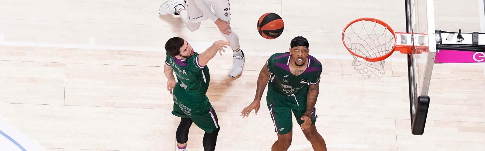 Darío Brizuela anota una bomba ante la mirada de Malcolm Thomas