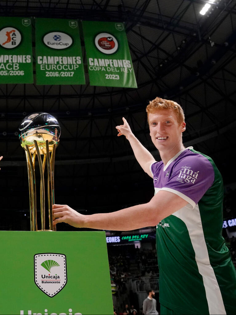 Alberto Díaz señala la banderola del título de Copa recién subida al techo del Carpena